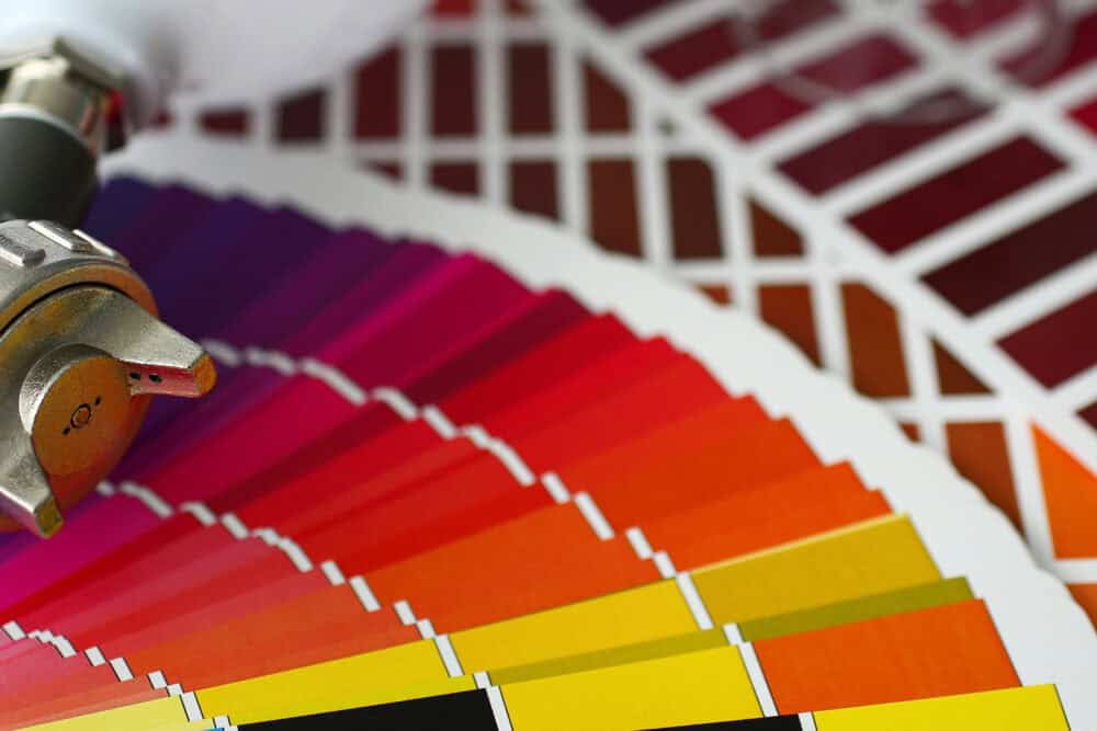 Closeup view of airbrush gun lying at colour check tables